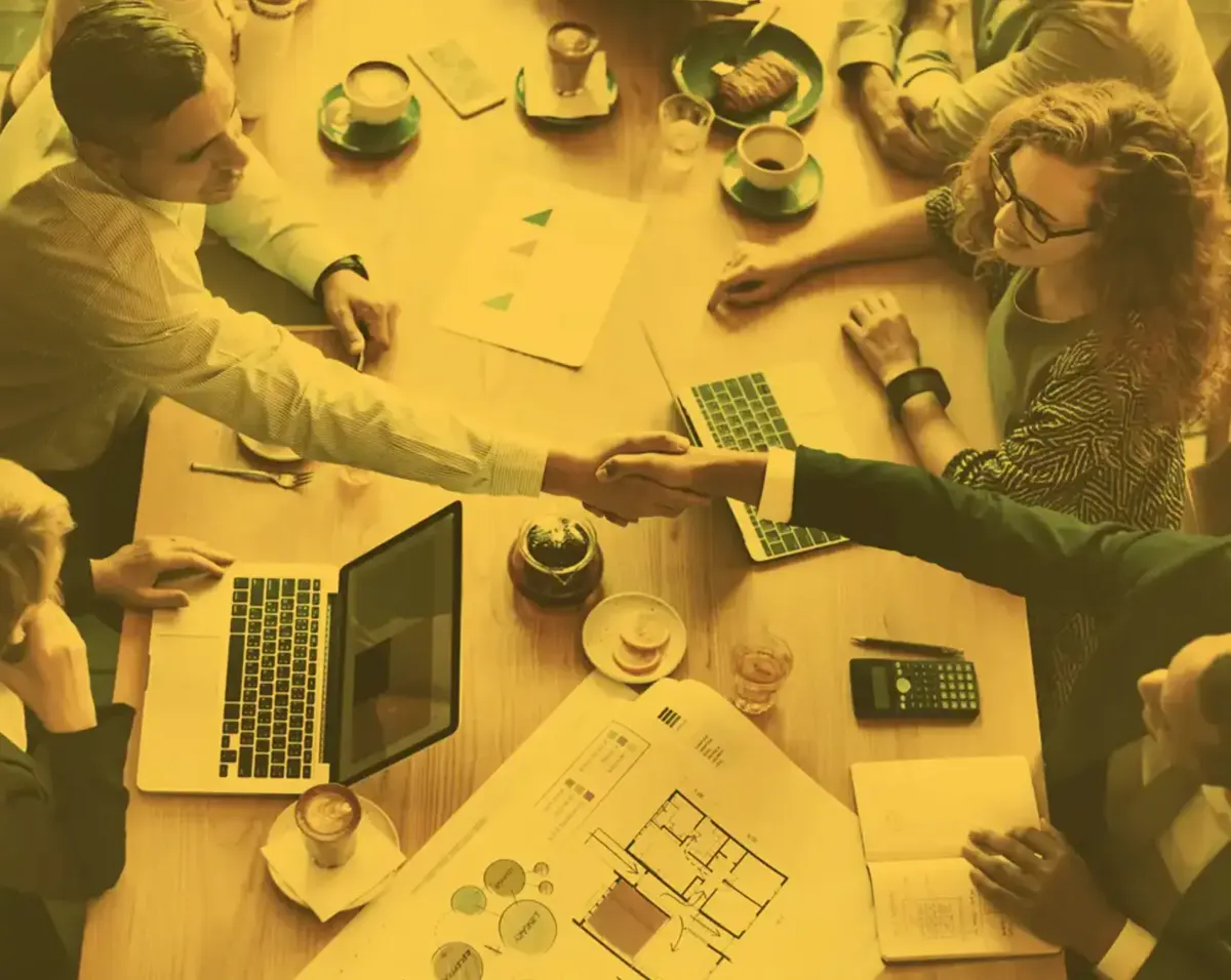 The Match and Harmony team shaking hands around a meeting table